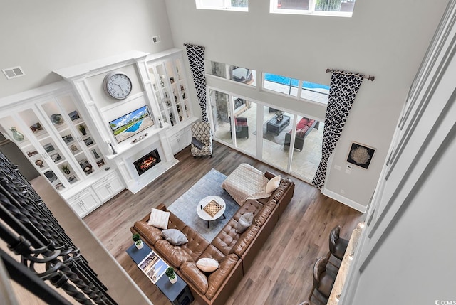 living room with dark hardwood / wood-style floors, a high ceiling, and a healthy amount of sunlight