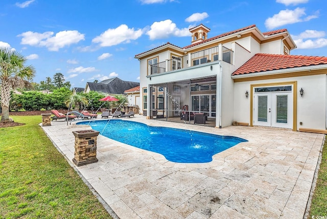 view of swimming pool with french doors, a lawn, a patio area, and pool water feature