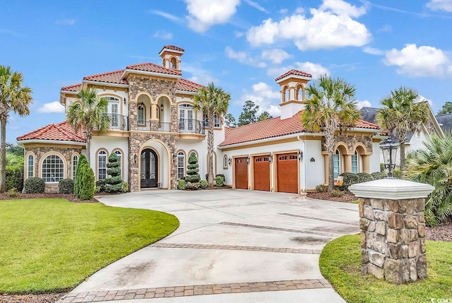 mediterranean / spanish house featuring a front yard, a balcony, and a garage