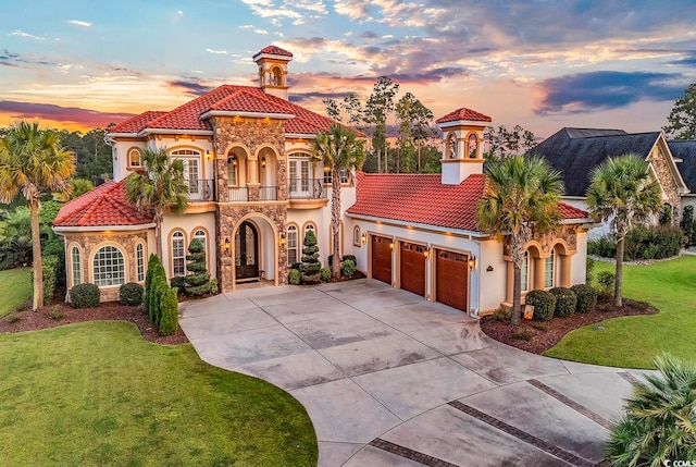 mediterranean / spanish home with a balcony, a garage, and a yard