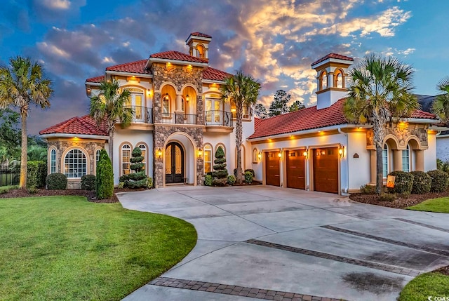 mediterranean / spanish-style home with a balcony, a yard, and a garage