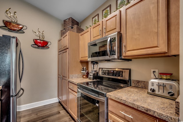 kitchen featuring light brown cabinetry, dark hardwood / wood-style flooring, and stainless steel appliances