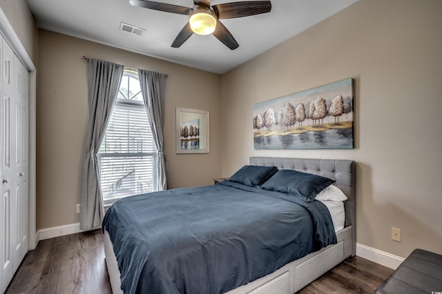 bedroom with dark hardwood / wood-style floors, ceiling fan, and a closet