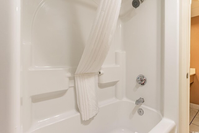 bathroom with shower / bath combo with shower curtain and tile patterned floors