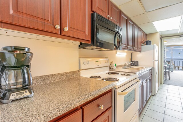 kitchen featuring sink, light tile patterned floors, a drop ceiling, electric range, and light stone countertops