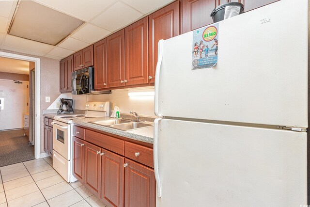 kitchen with white appliances, sink, light tile patterned floors, and a drop ceiling