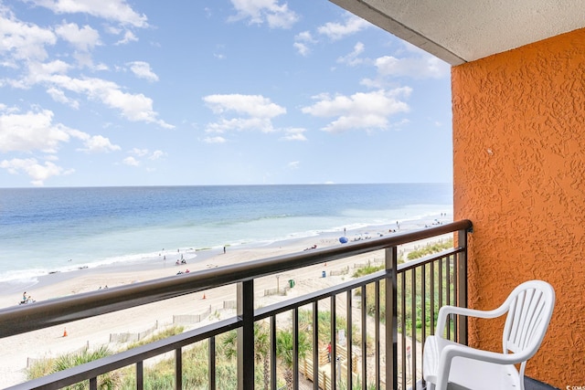 balcony featuring a view of the beach and a water view