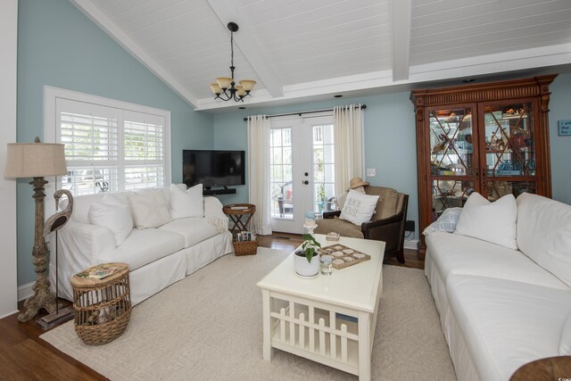 living room with hardwood / wood-style flooring, a chandelier, lofted ceiling with beams, and a wealth of natural light