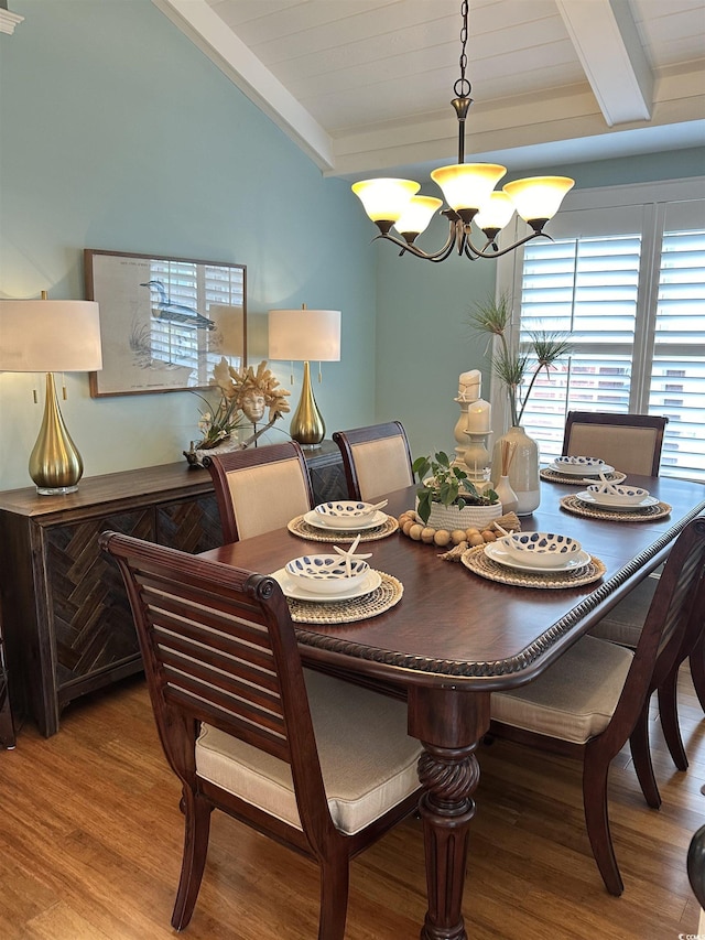 dining room with vaulted ceiling with beams, wood-type flooring, and a notable chandelier