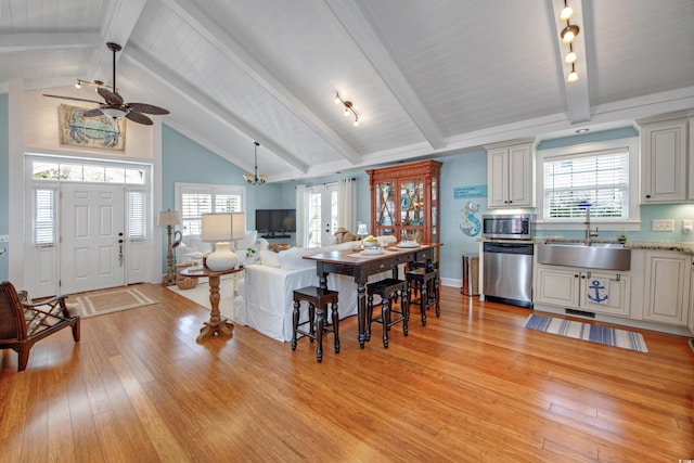 kitchen with sink, beamed ceiling, and appliances with stainless steel finishes