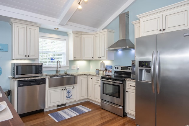 kitchen featuring dark hardwood / wood-style floors, lofted ceiling with beams, sink, stainless steel appliances, and wall chimney exhaust hood