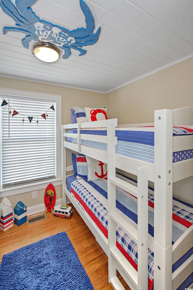 bedroom with wood-type flooring, ornamental molding, and wood ceiling