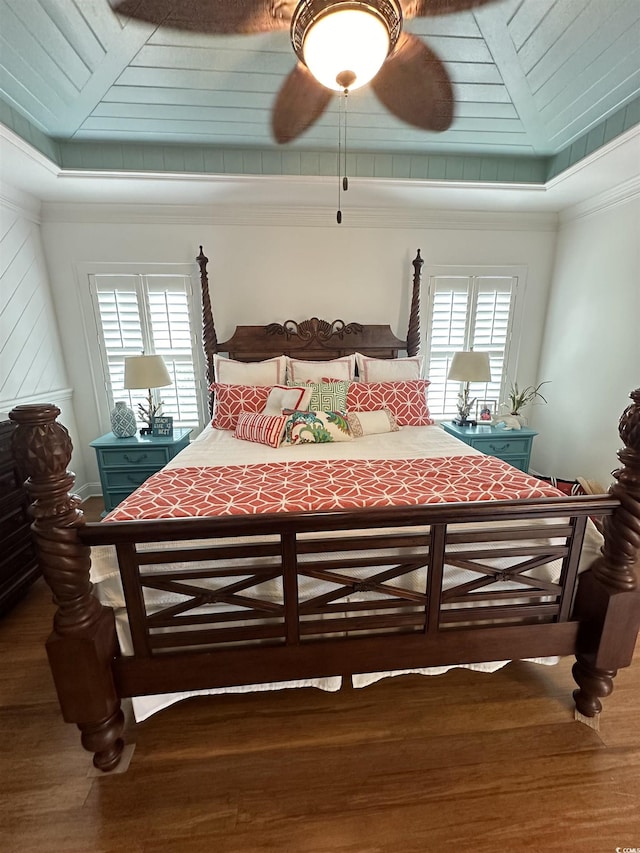 bedroom with dark wood-type flooring, ceiling fan, ornamental molding, and multiple windows