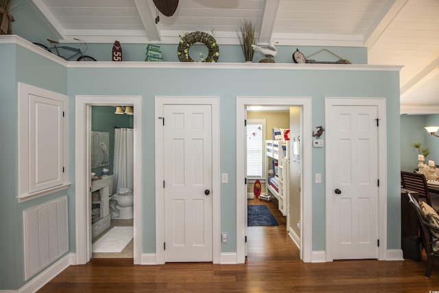 interior space featuring dark hardwood / wood-style flooring and vaulted ceiling with beams