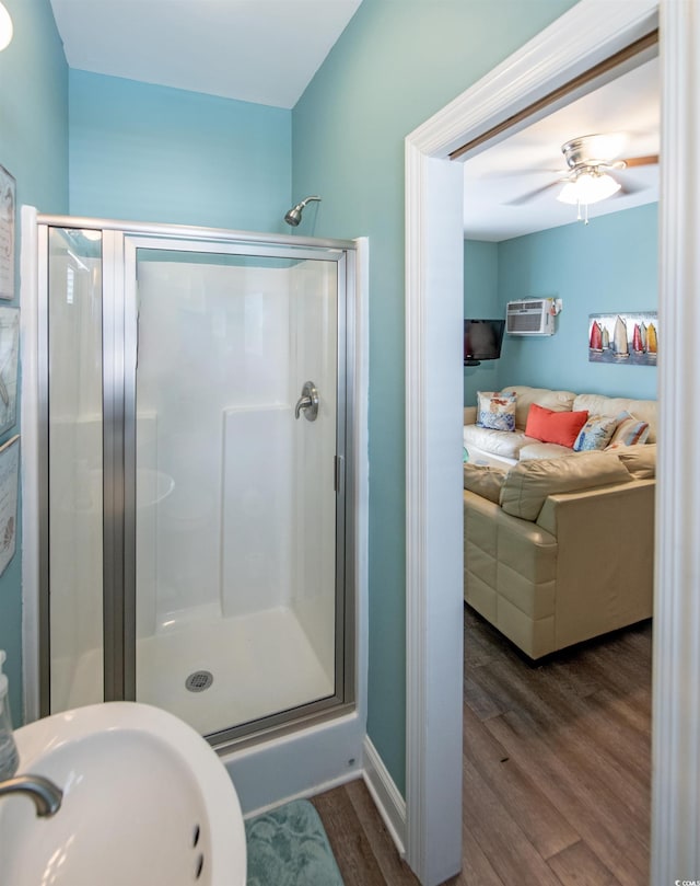 bathroom featuring a wall mounted air conditioner, hardwood / wood-style floors, sink, ceiling fan, and walk in shower