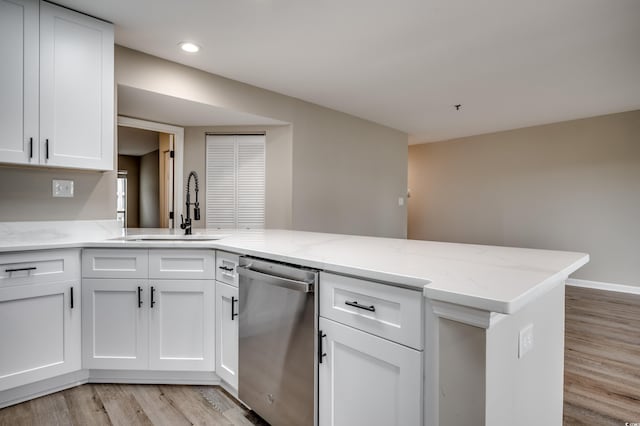 kitchen with white cabinets, kitchen peninsula, dishwasher, light wood-type flooring, and sink