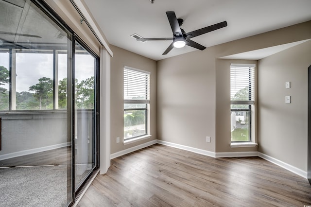 unfurnished room with ceiling fan, hardwood / wood-style floors, and a wealth of natural light