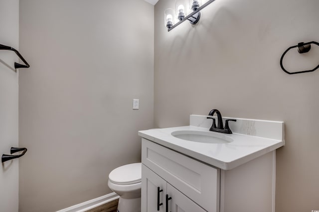 bathroom featuring wood-type flooring, vanity, and toilet