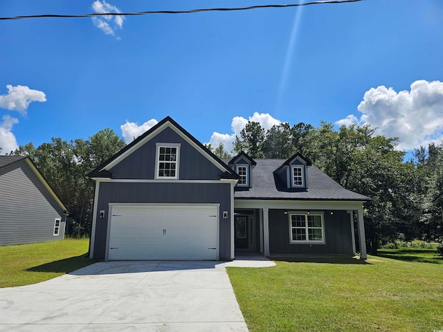 view of front facade featuring a front yard, a garage, and a porch