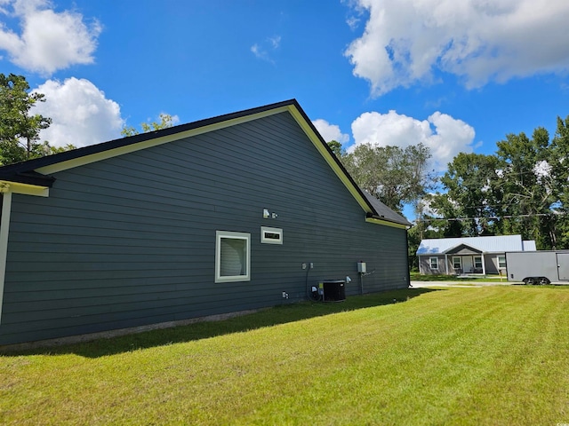 view of property exterior with cooling unit and a yard