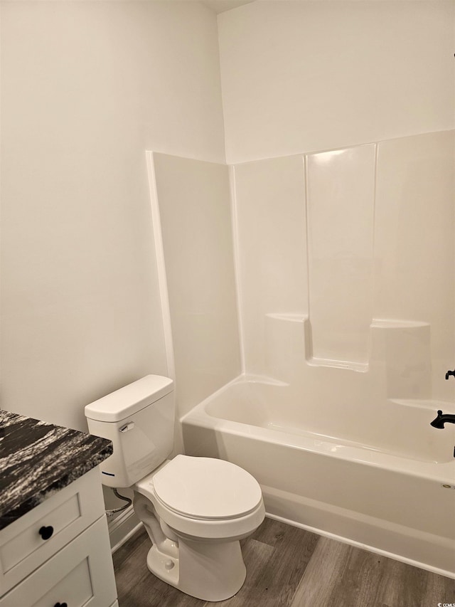 full bathroom featuring hardwood / wood-style floors, vanity, toilet, and bathtub / shower combination