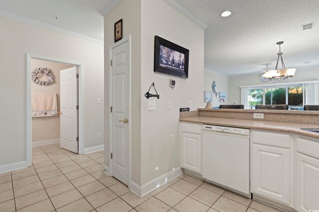 laundry room featuring ornamental molding, a textured ceiling, light tile patterned floors, and washing machine and clothes dryer