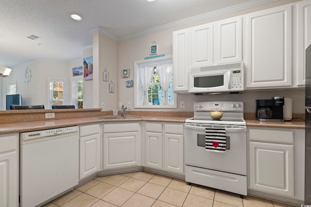 1100 Commons Blvd Unit 104, Myrtle Beach, SC 29572 - kitchen featuring white appliances, healthy amount of natural light, ornamental molding, light tile patterned floors, and white cabinetry