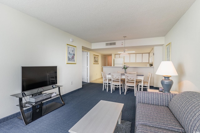 living room with a textured ceiling and carpet flooring