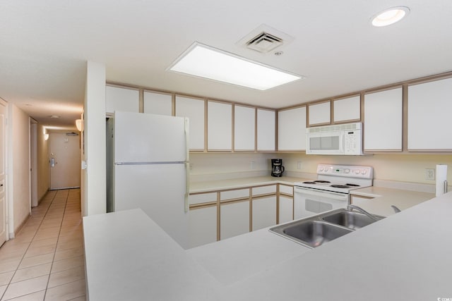 kitchen with white appliances, light tile patterned flooring, sink, and white cabinets