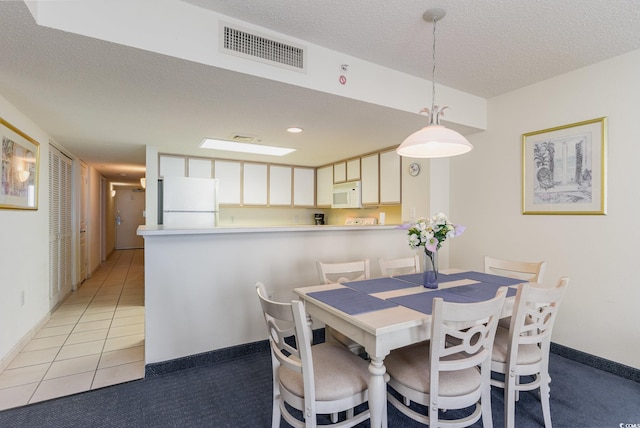 dining room with a textured ceiling and light tile patterned floors