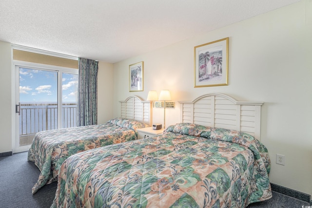 bedroom with access to exterior, a textured ceiling, and carpet flooring