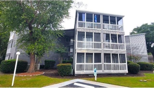 back of house featuring a yard and a balcony