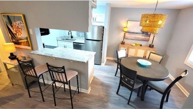10166 Beach Dr Unit 5306, Calabash, NC 28467 - kitchen featuring freestanding refrigerator, a sink, baseboards, and a breakfast bar
