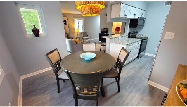 10166 Beach Dr Unit 5306, Calabash, NC 28467 - dining area featuring baseboards, plenty of natural light, and light wood finished floors