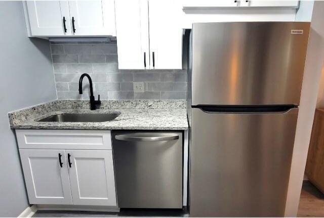 10166 Beach Dr Unit 5306, Calabash, NC 28467 - kitchen featuring stainless steel appliances, a sink, decorative backsplash, and white cabinetry