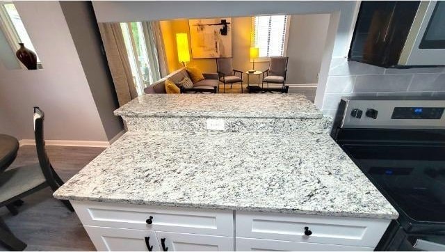 10166 Beach Dr Unit 5306, Calabash, NC 28467 - kitchen featuring electric range oven, baseboards, white cabinetry, backsplash, and dark wood-type flooring