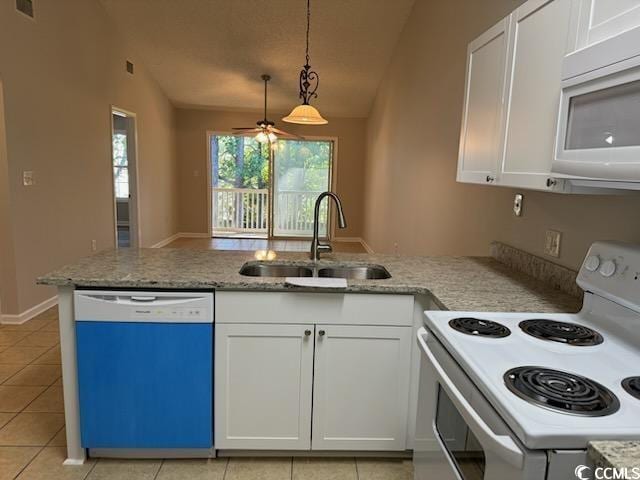 kitchen featuring white cabinets, vaulted ceiling, light tile patterned flooring, sink, and white appliances