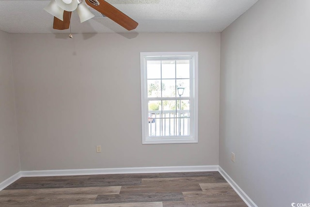 empty room featuring ceiling fan, a textured ceiling, and dark hardwood / wood-style flooring