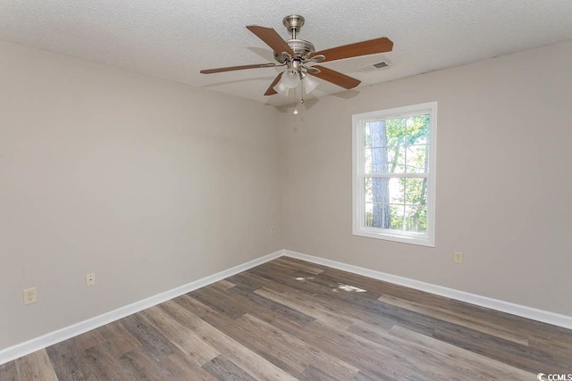 spare room featuring a textured ceiling, wood-type flooring, and ceiling fan