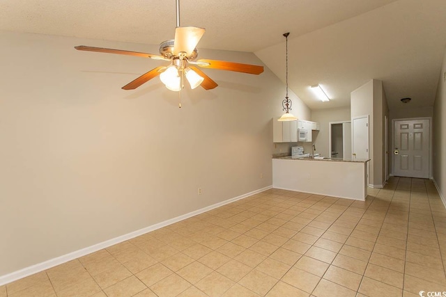 unfurnished living room featuring ceiling fan, vaulted ceiling, and light tile patterned floors