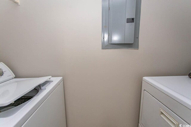 laundry area featuring electric panel and washing machine and clothes dryer