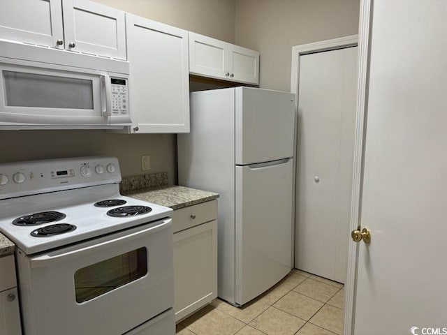 kitchen with white cabinetry, light tile patterned floors, and white appliances