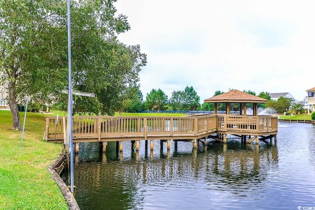 view of dock with a lawn, a water view, and a gazebo