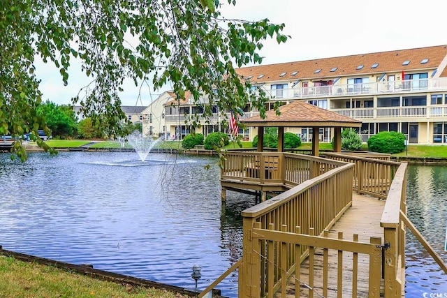 view of dock featuring a gazebo, a water view, and a balcony