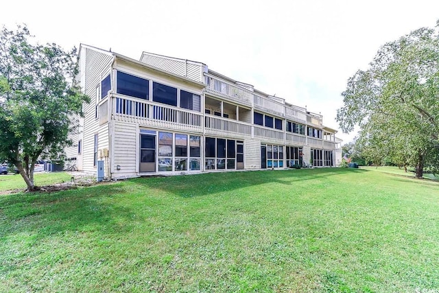 rear view of property featuring central AC and a yard