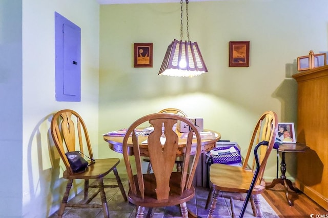 dining space with electric panel and hardwood / wood-style floors