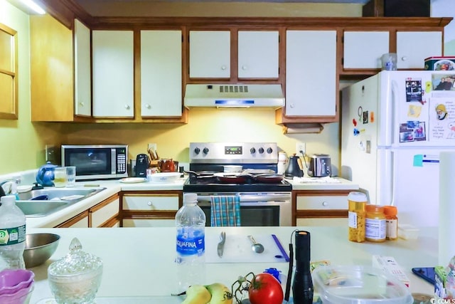 kitchen with appliances with stainless steel finishes, white cabinetry, sink, and extractor fan