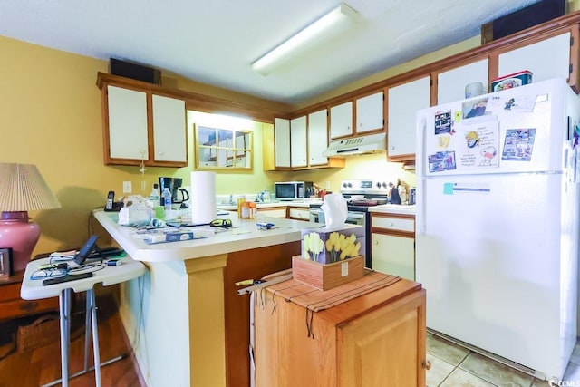 kitchen featuring a kitchen bar, white cabinetry, light tile patterned floors, and stainless steel appliances