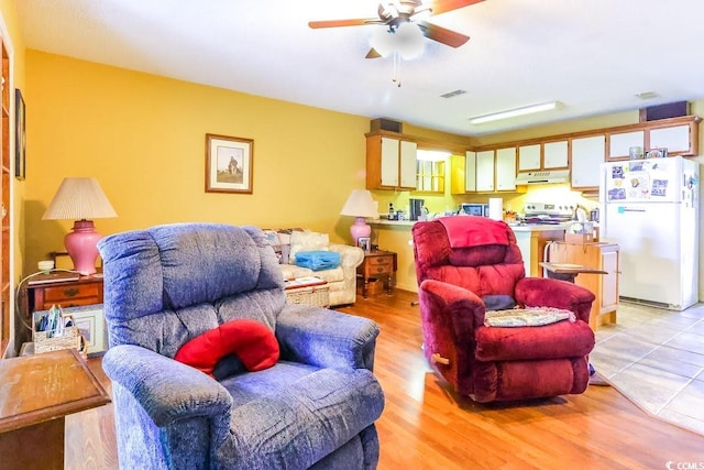 living room with ceiling fan and light hardwood / wood-style floors