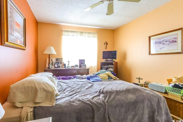 bedroom featuring ceiling fan and a textured ceiling